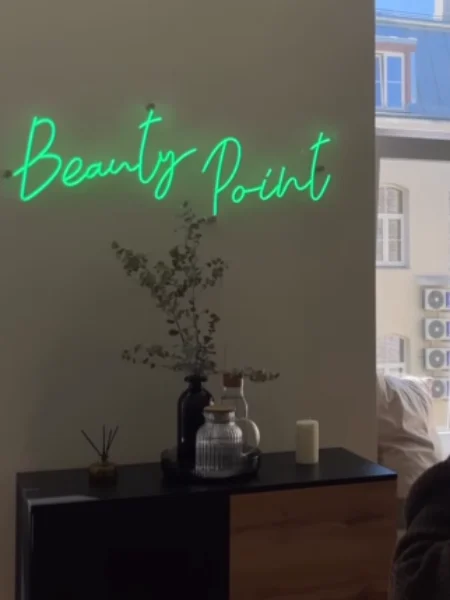 Green script LED neon sign in a beauty salon