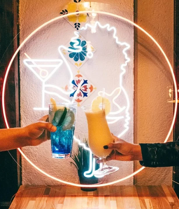 Round white LED neon sign above a cocktail bar