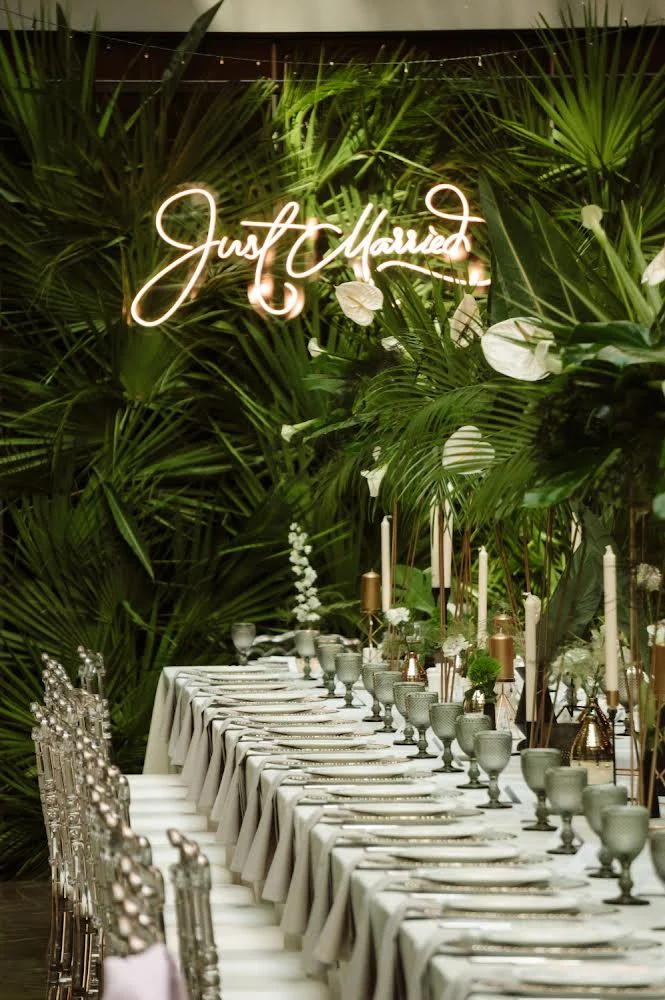 Warm white Just Married LED neon script sign above a wedding banquet table