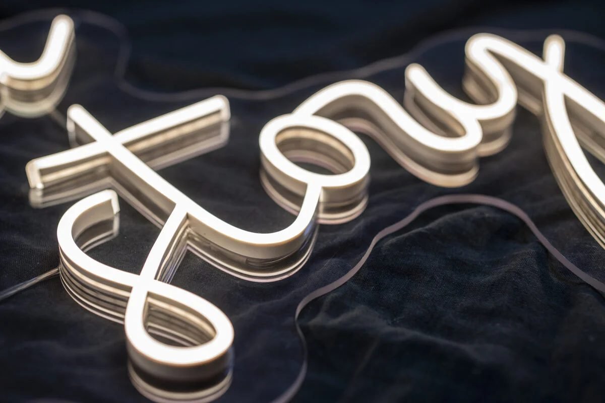 Close-up of a warm white LED neon script sign