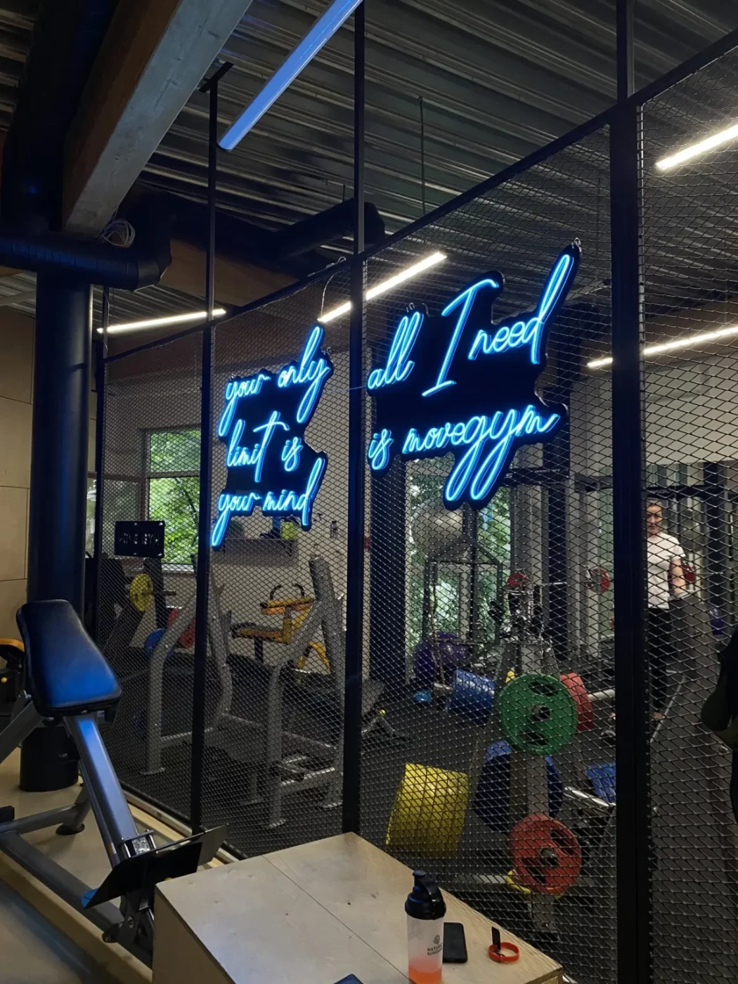Blue LED neon script lettering on a gym wall