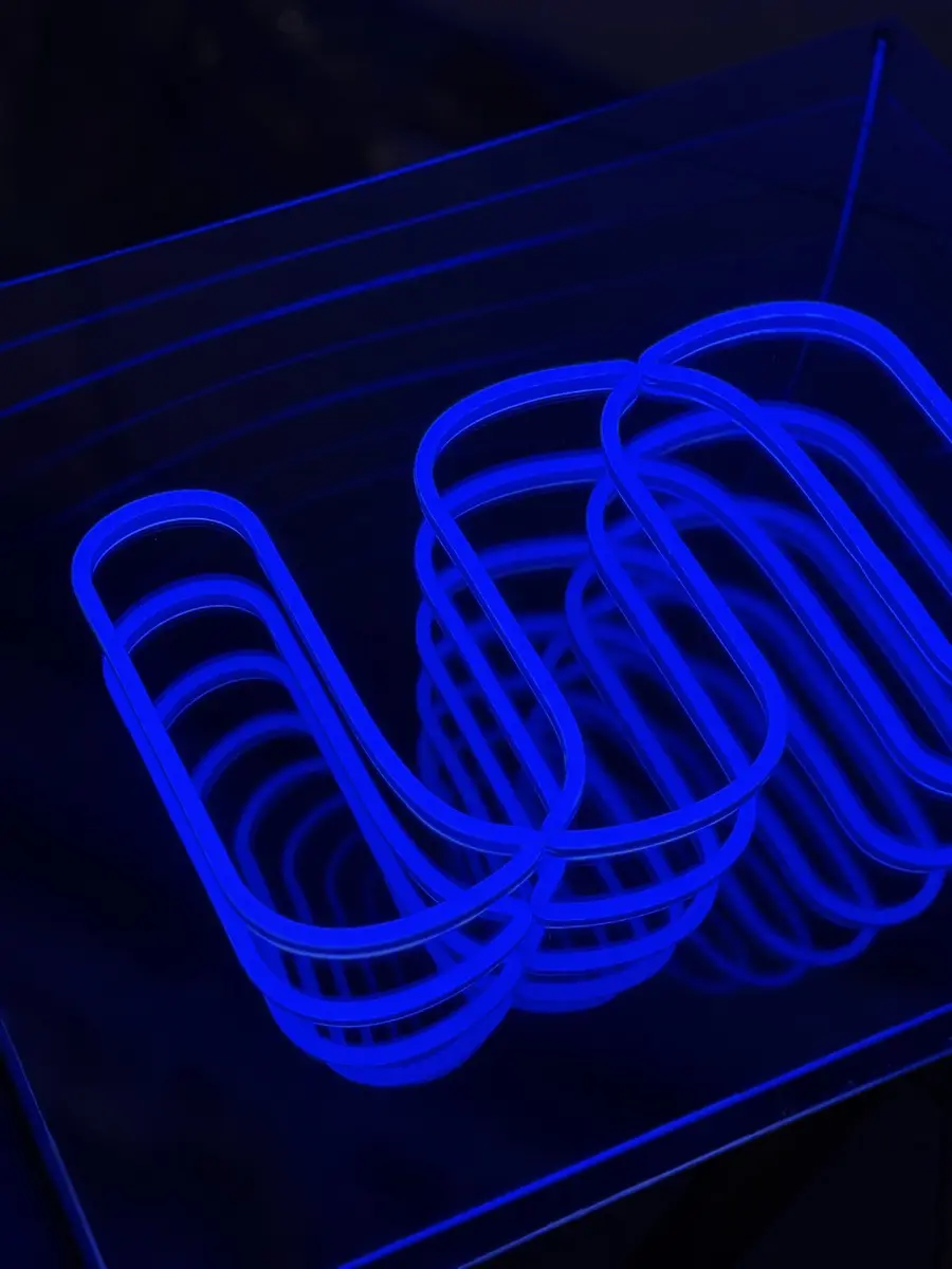 Close-up of infinity mirror LED neon letters repeating into depth