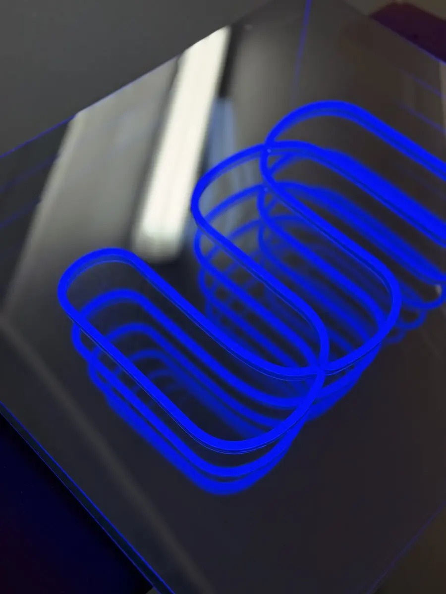 Infinity mirror LED neon sign seen in daylight with reflections in the mirror surface