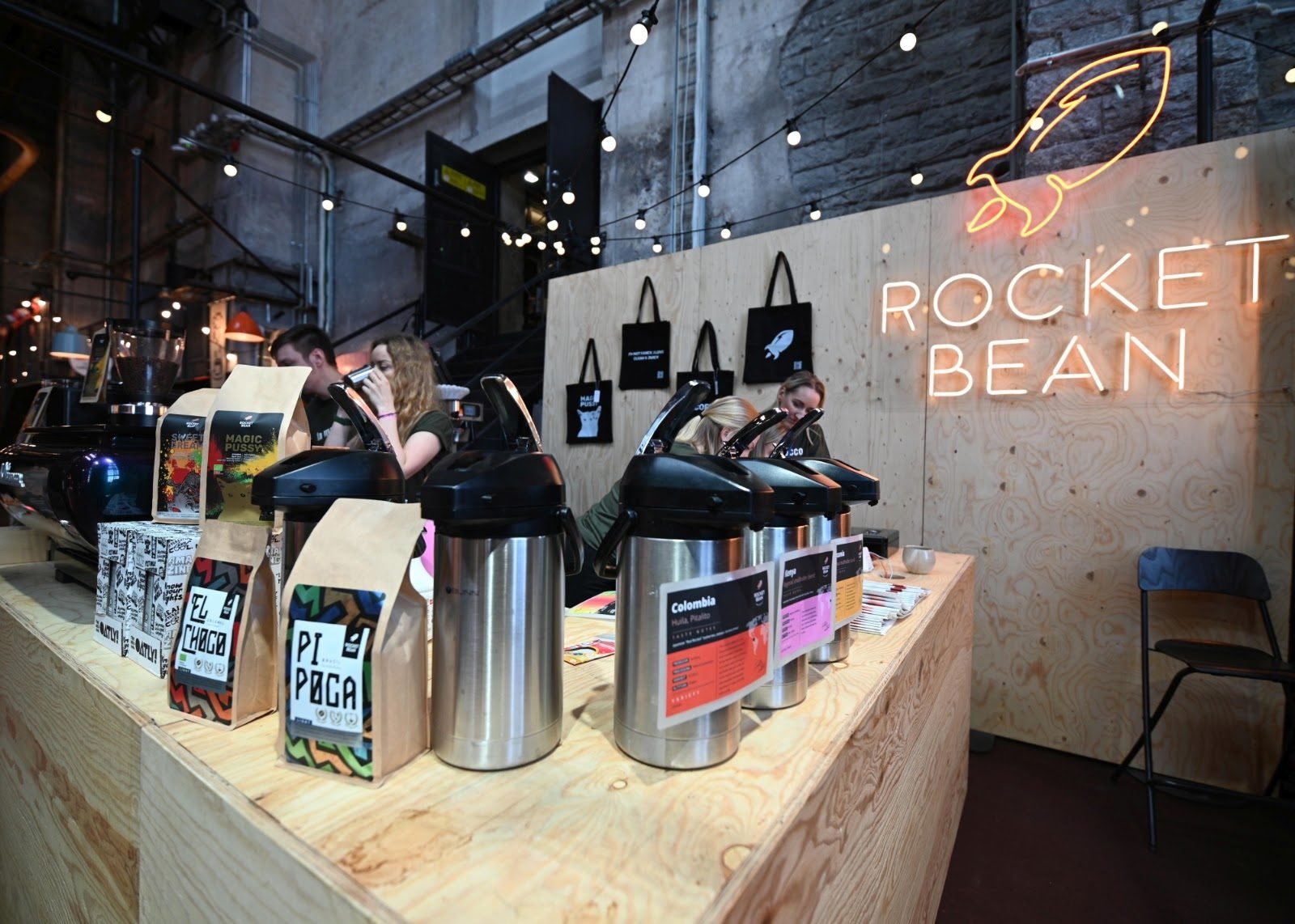 Coffee roaster's market stand with an orange neon logo