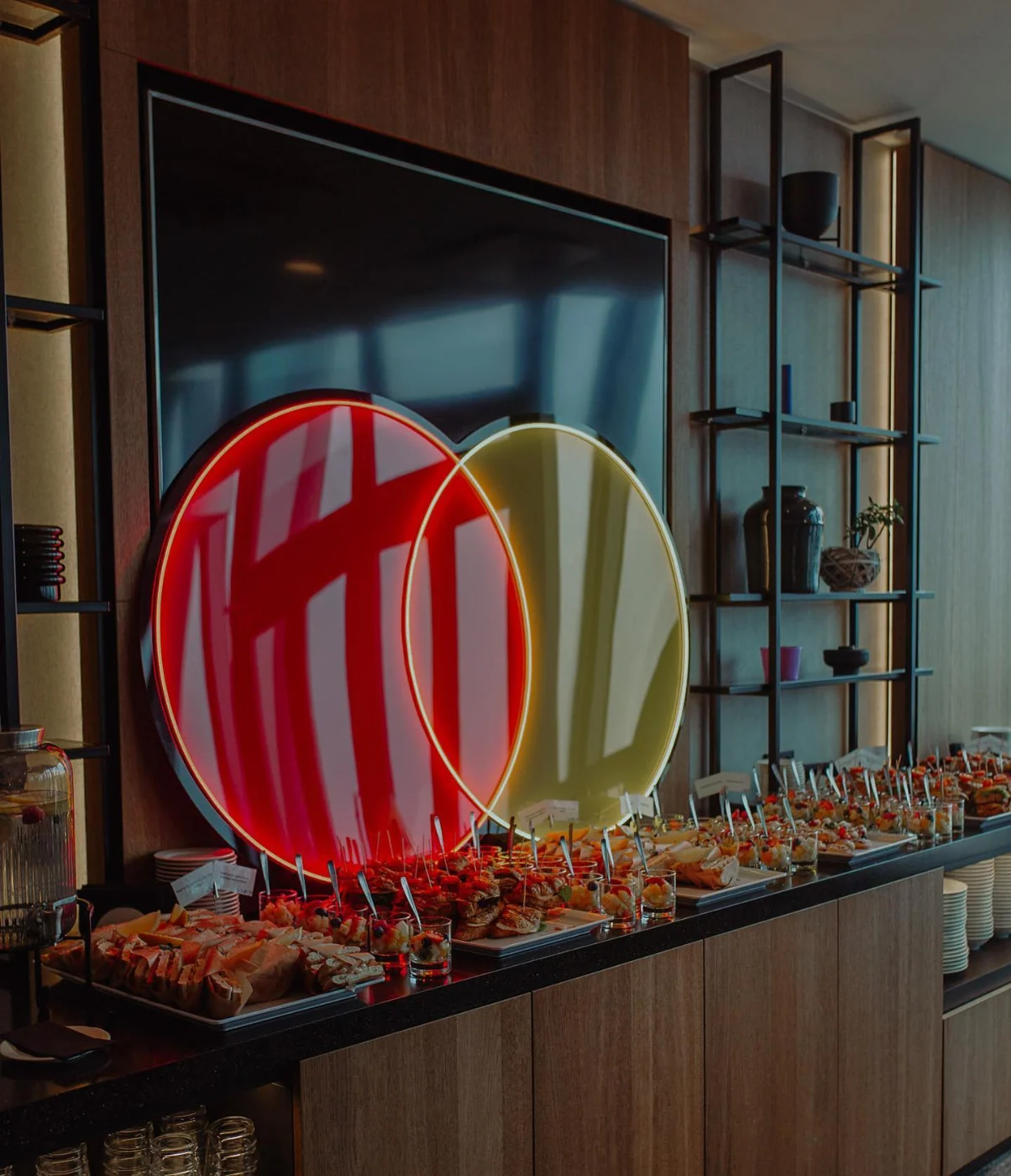 Red and yellow LED neon logo above an office bar counter