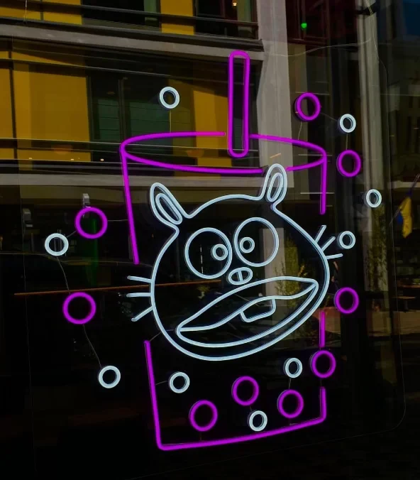 Pink LED neon cat and bubble-tea cup sign in a shop window