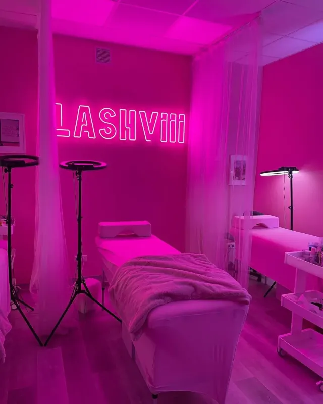 Pink LED neon sign in a lash salon treatment room