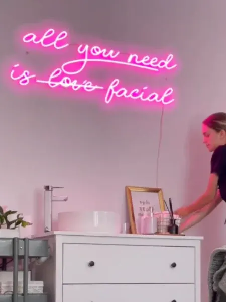 Pink LED neon slogan above a facial treatment station