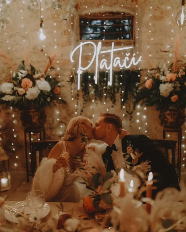 Warm white LED neon script sign behind a newlywed couple