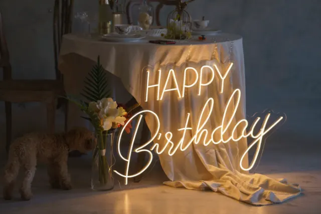 Warm white LED neon Happy Birthday sign above a party table