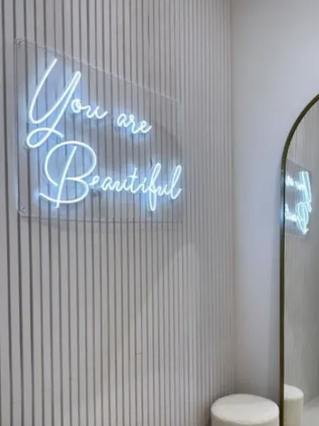 White LED neon You are Beautiful sign beside a mirror
