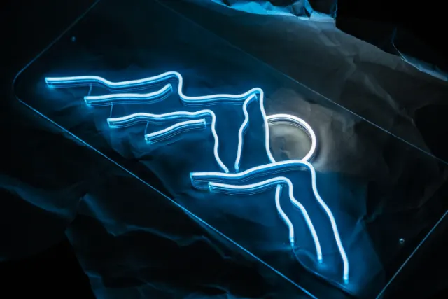 LED neon line-art sign glowing in a dark room