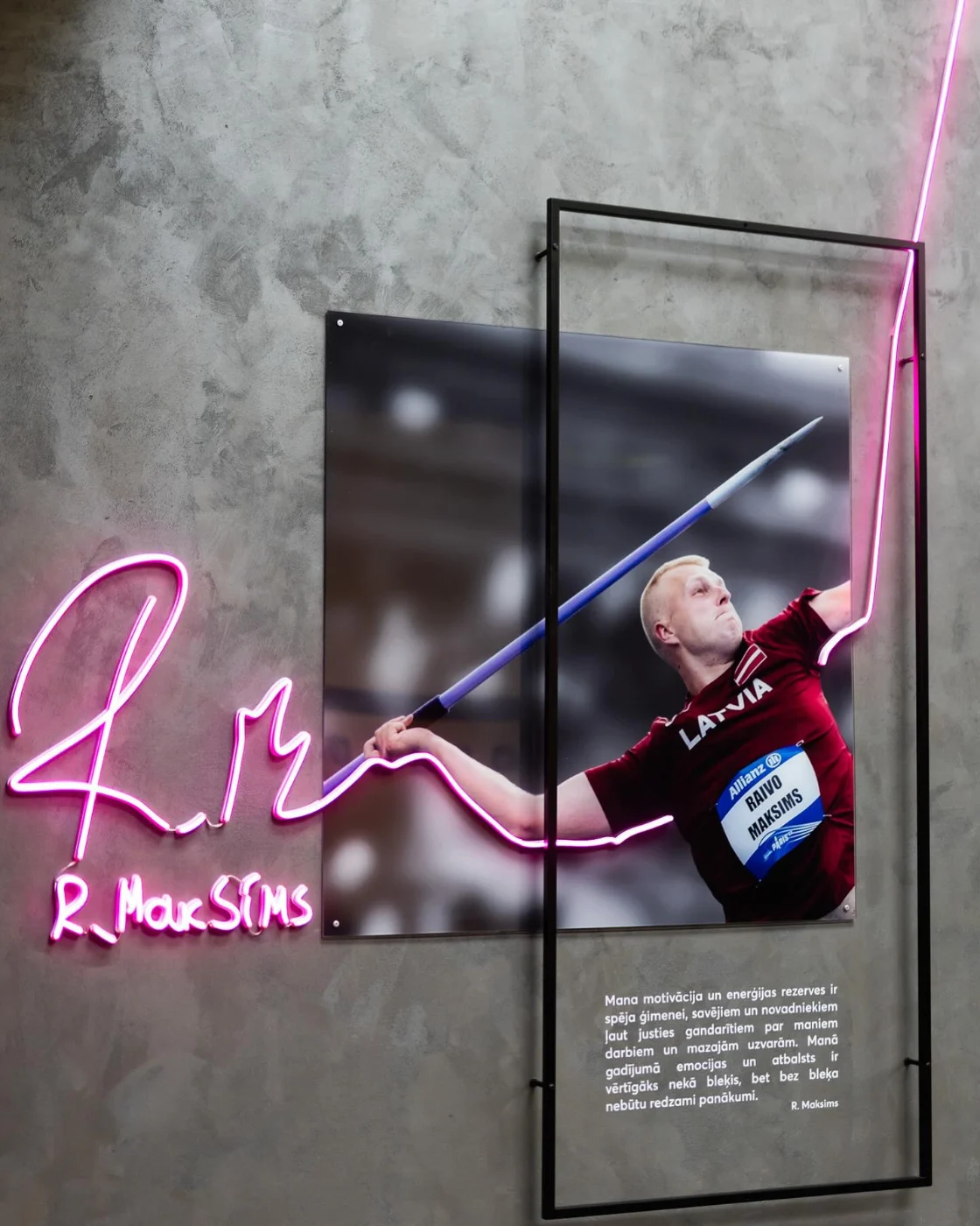 Pink LED neon signature running into an athlete portrait installation